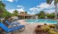 a pool with chairs and a building in the background