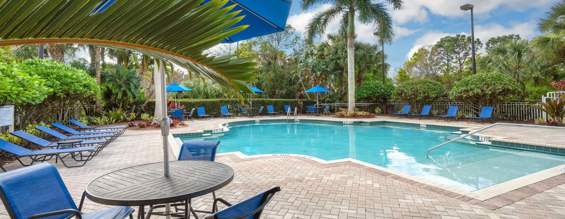 a pool with chairs and umbrellas by it